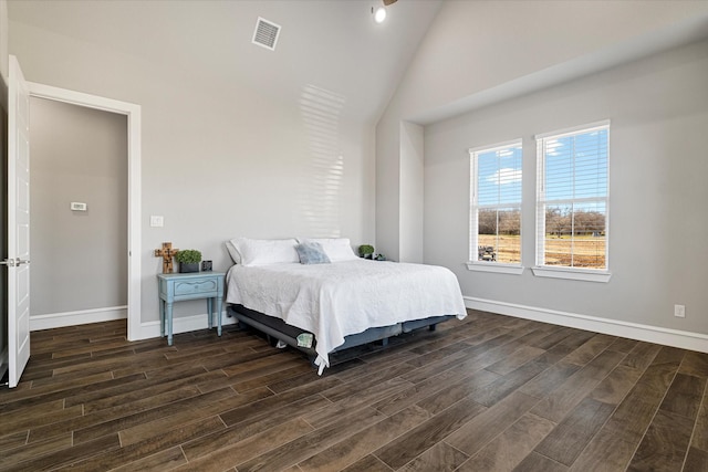 bedroom with visible vents, baseboards, dark wood finished floors, and vaulted ceiling