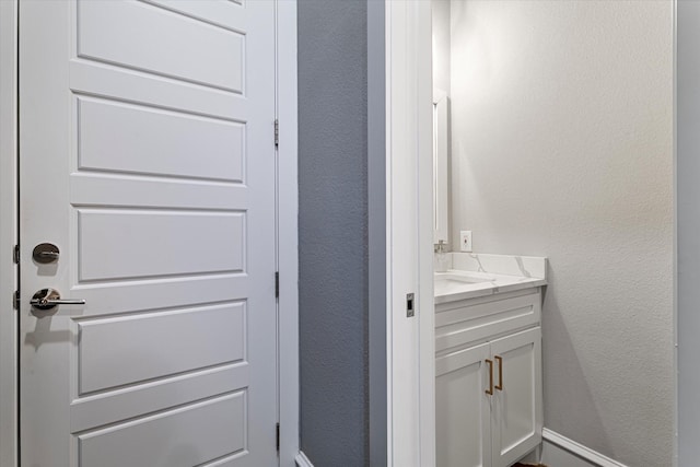 bathroom with vanity and a textured wall