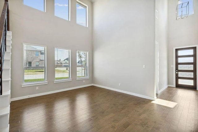 foyer featuring baseboards, dark wood-style flooring, and a wealth of natural light