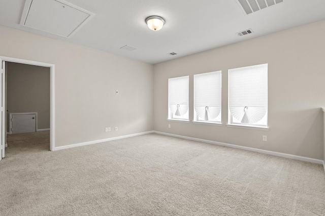 unfurnished room with carpet, visible vents, and baseboards