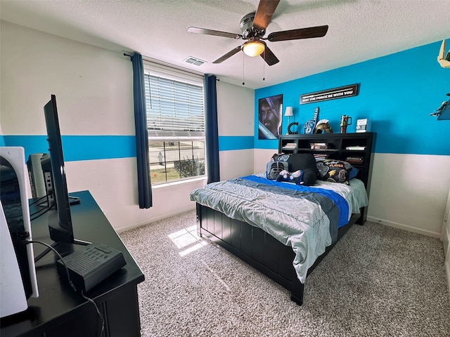 bedroom with a textured ceiling, ceiling fan, visible vents, baseboards, and carpet