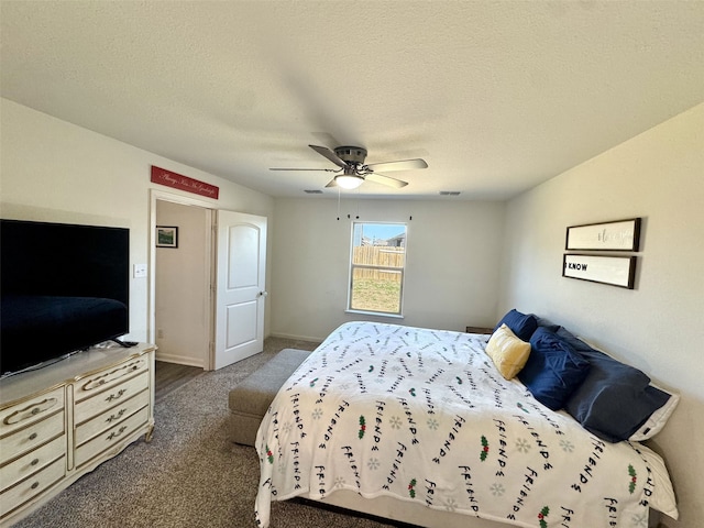 bedroom featuring ceiling fan, baseboards, dark colored carpet, and a textured ceiling