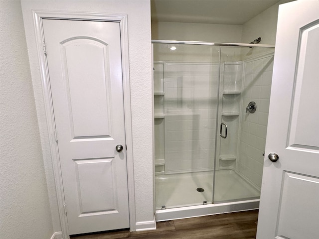 full bath with a stall shower and wood finished floors