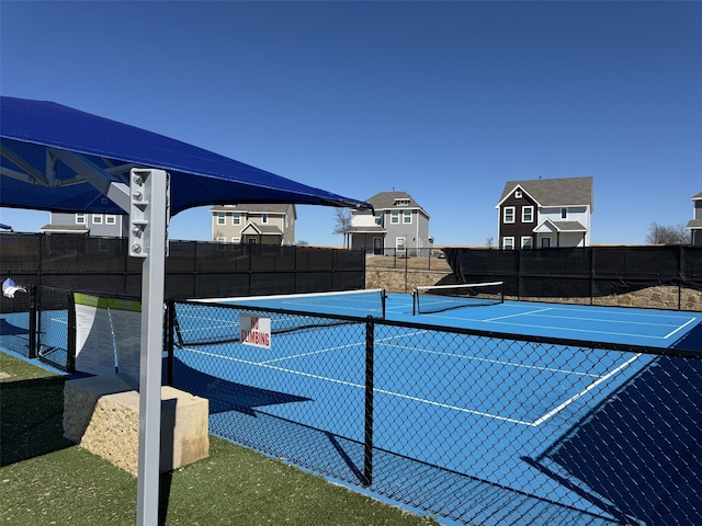 view of tennis court featuring fence