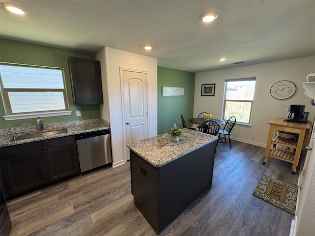 kitchen featuring a sink, light stone counters, dark wood finished floors, and dishwasher