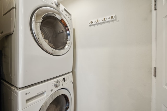 clothes washing area featuring stacked washer and clothes dryer