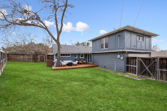 back of property with a fenced backyard, a lawn, a wooden deck, a gate, and board and batten siding