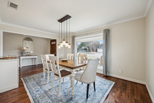 dining room with crown molding, visible vents, and dark wood-style flooring