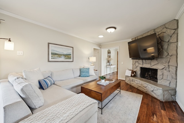 living area featuring ornamental molding, a fireplace, baseboards, and wood finished floors