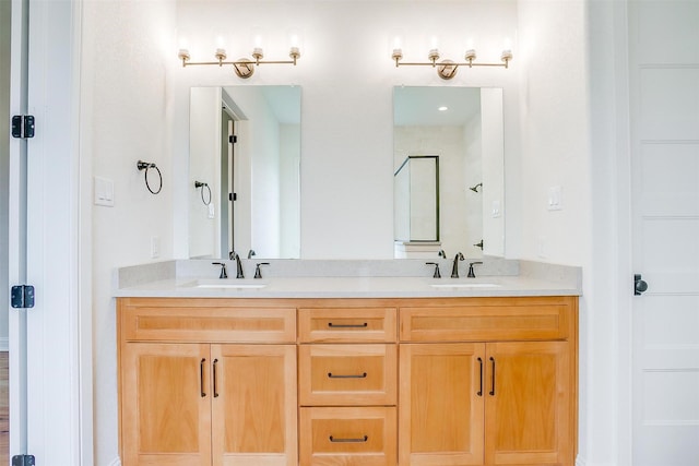 full bath featuring double vanity, a sink, and a shower with shower door