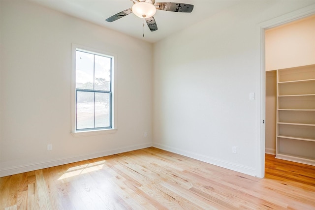 spare room with baseboards, ceiling fan, and light wood-style floors