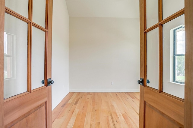 doorway featuring light wood-style floors and baseboards