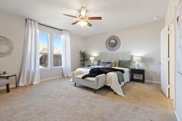 bedroom with light carpet, ceiling fan, and baseboards