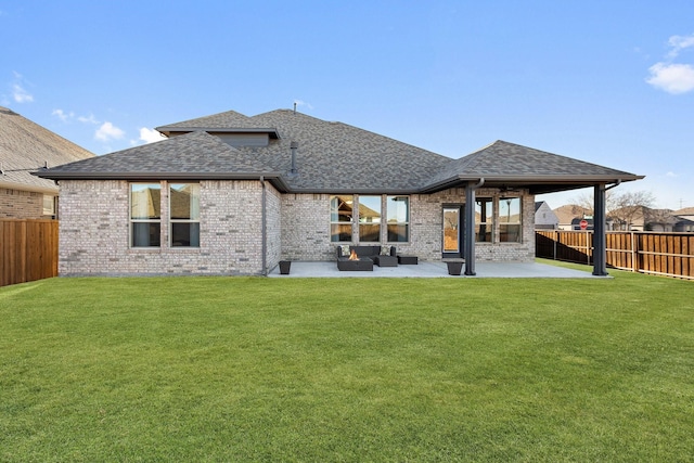 back of property with a patio area, a fenced backyard, a yard, and roof with shingles