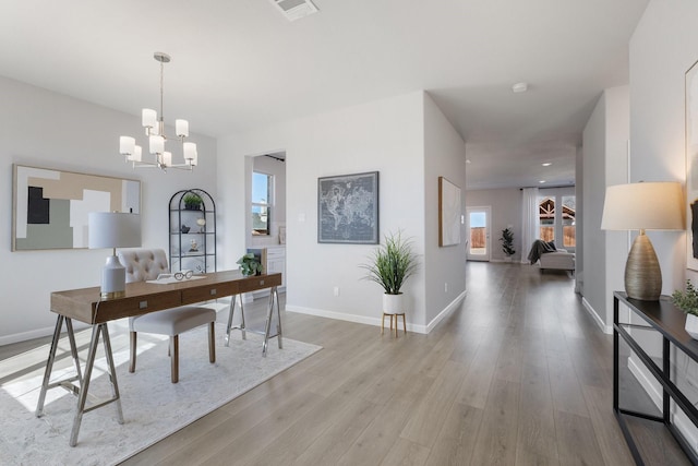 home office with a chandelier, visible vents, baseboards, and wood finished floors