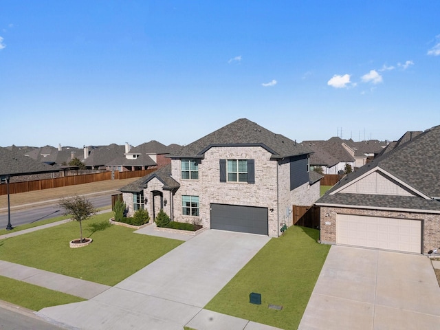 view of front of home with a shingled roof, a front yard, concrete driveway, and fence