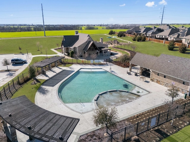 view of pool with a patio, fence, and a pool with connected hot tub