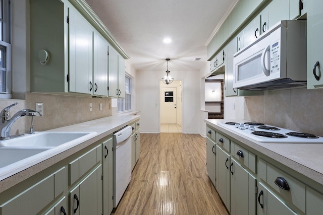 kitchen with white appliances, light wood-style flooring, light countertops, and a sink