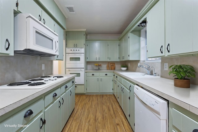 kitchen featuring light countertops, white appliances, visible vents, and a sink