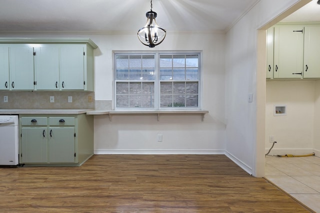 kitchen with crown molding, white dishwasher, light countertops, and wood finished floors