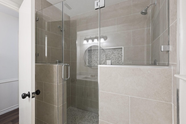 bathroom with a stall shower and wood finished floors