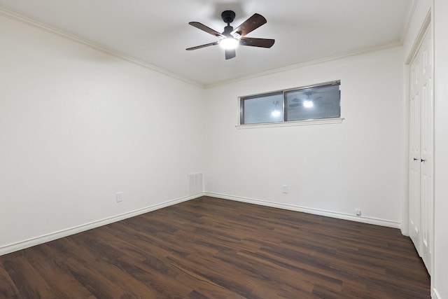 unfurnished bedroom featuring dark wood-style floors, visible vents, baseboards, and crown molding