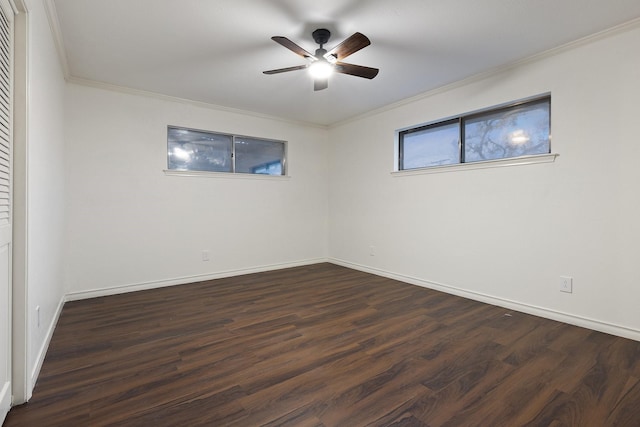 empty room featuring ceiling fan, ornamental molding, dark wood-style flooring, and baseboards