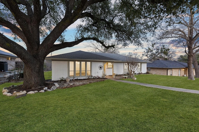 single story home featuring a front yard and brick siding