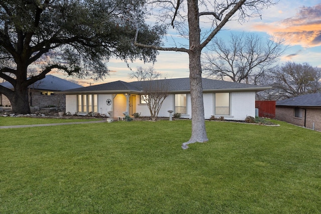 view of front of home with brick siding and a front lawn