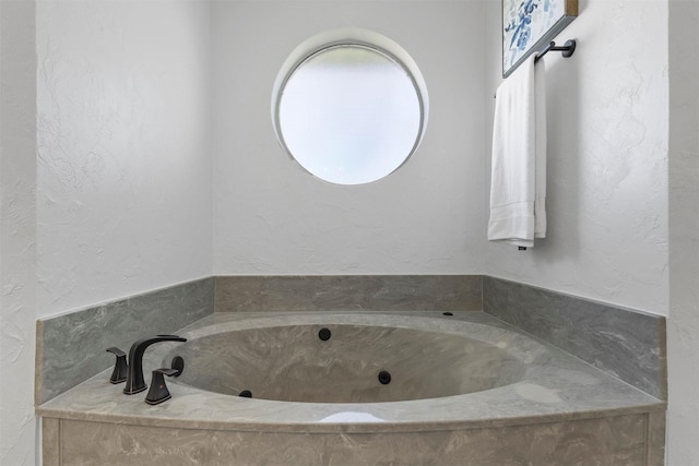 full bath with a garden tub and a textured wall