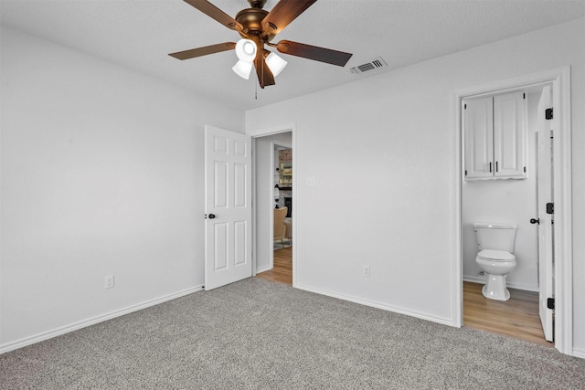 unfurnished bedroom featuring carpet flooring, visible vents, and baseboards