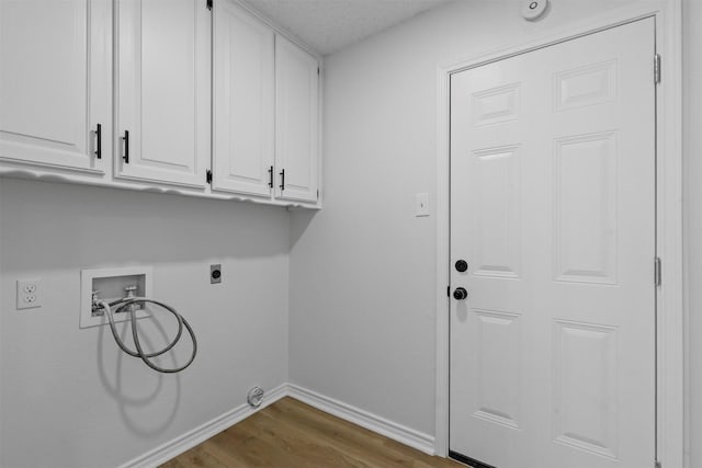 laundry room with washer hookup, cabinet space, electric dryer hookup, wood finished floors, and baseboards