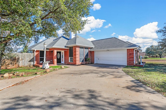 view of front facade featuring an attached garage, brick siding, fence, driveway, and roof with shingles