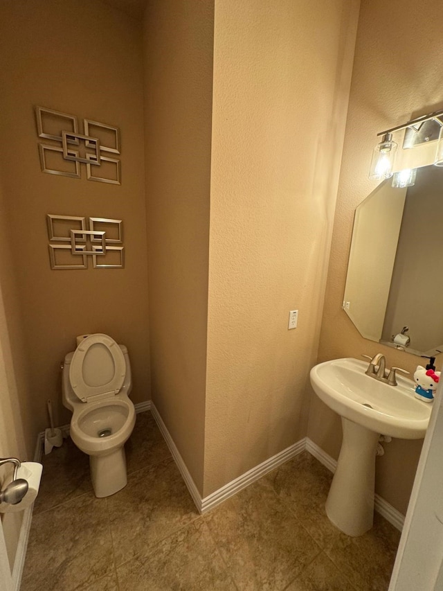 bathroom with toilet and baseboards