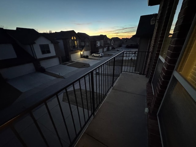 balcony at dusk featuring a residential view