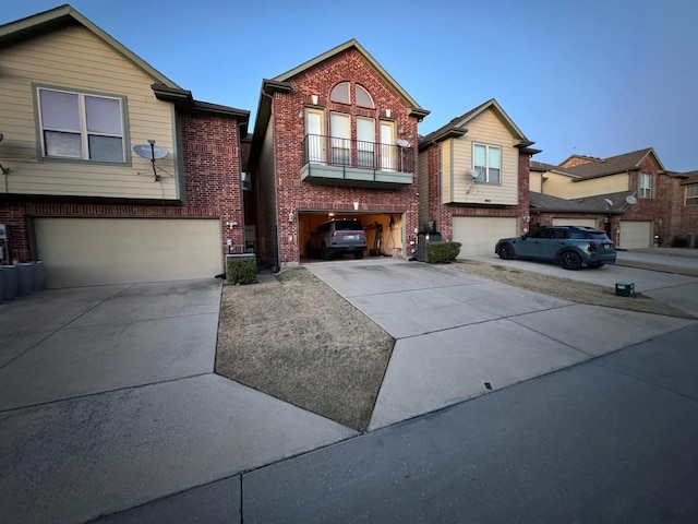 view of front of property with brick siding, driveway, a balcony, and an attached garage