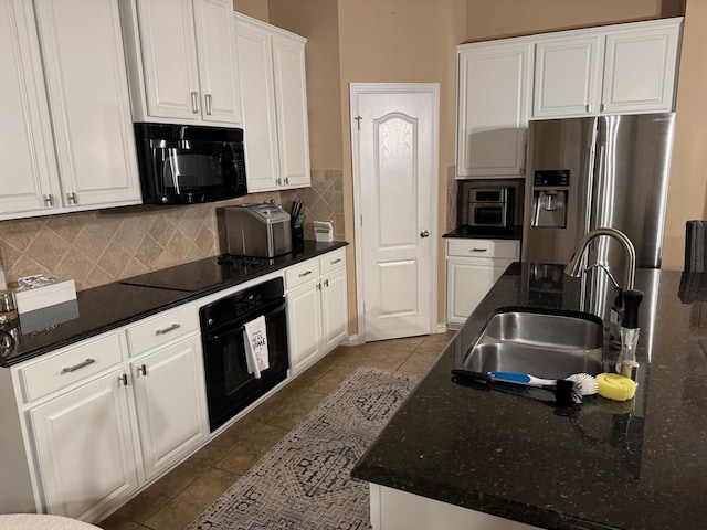 kitchen featuring dark tile patterned flooring, a sink, white cabinetry, backsplash, and black appliances