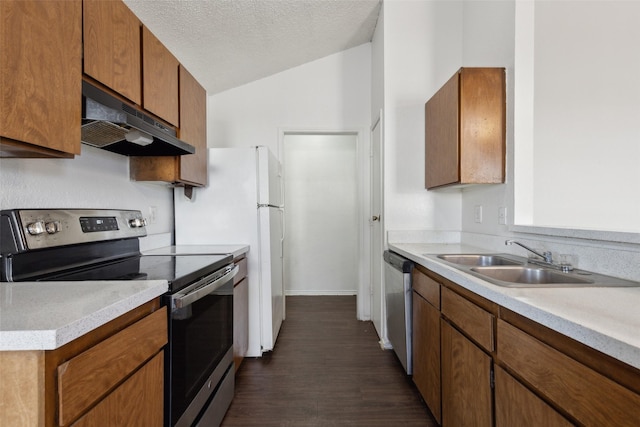 kitchen featuring appliances with stainless steel finishes, vaulted ceiling, a sink, a textured ceiling, and under cabinet range hood