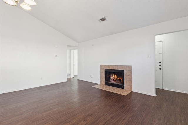 unfurnished living room featuring wood finished floors, visible vents, baseboards, vaulted ceiling, and a tiled fireplace