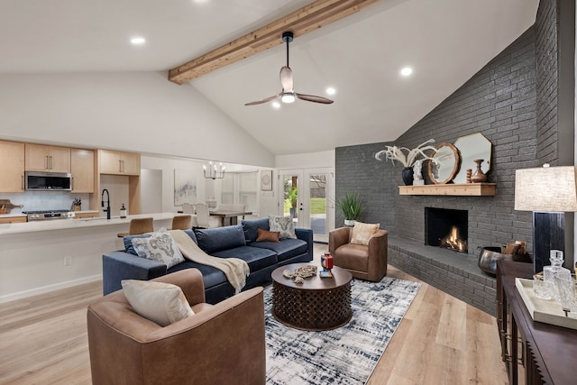 living area featuring high vaulted ceiling, a fireplace, french doors, light wood-type flooring, and beam ceiling