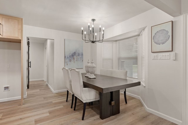 dining space with light wood-type flooring, baseboards, and a chandelier