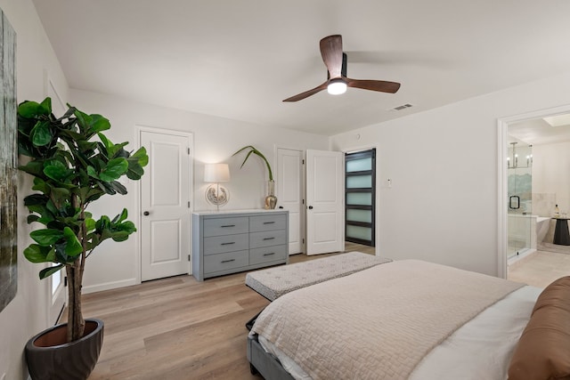 bedroom with light wood finished floors, ceiling fan, visible vents, and connected bathroom