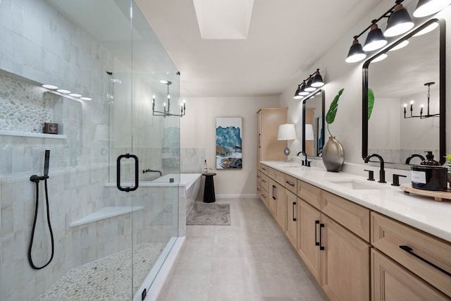 full bath with a stall shower, tile patterned flooring, a sink, and an inviting chandelier