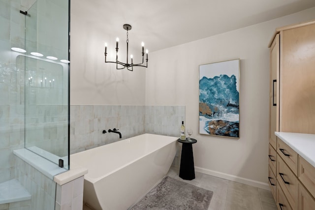 bathroom featuring a notable chandelier, a soaking tub, tiled shower, baseboards, and tile patterned floors