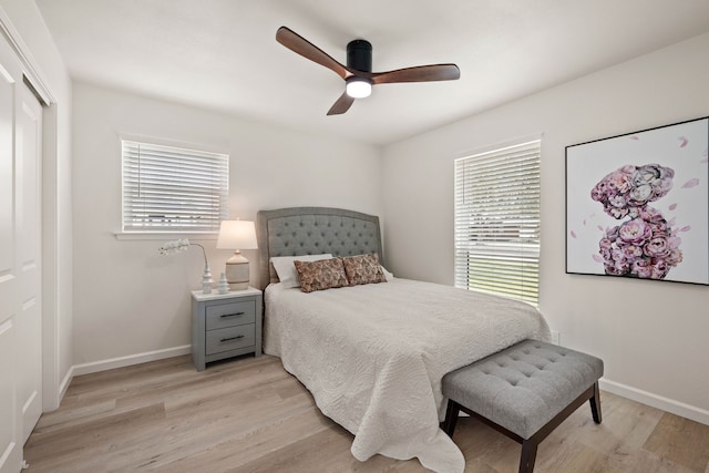 bedroom featuring light wood-style floors, multiple windows, and baseboards