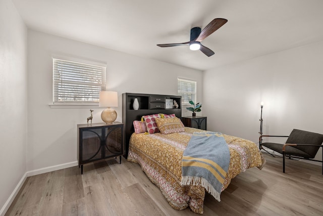 bedroom with ceiling fan, light wood-type flooring, and baseboards