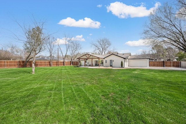 exterior space featuring a garage, a fenced backyard, a lawn, and a patio