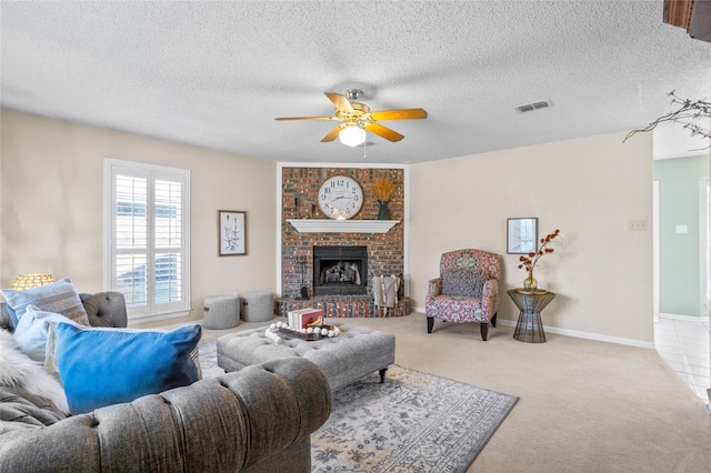 living area with carpet, visible vents, a brick fireplace, ceiling fan, and baseboards