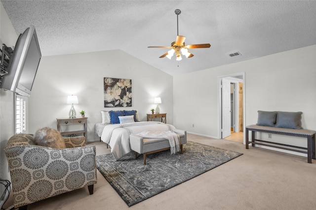 bedroom with carpet floors, lofted ceiling, visible vents, ceiling fan, and a textured ceiling