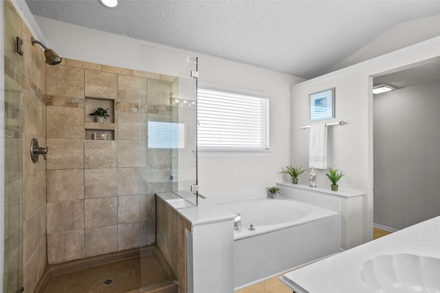 bathroom with a sink, a stall shower, vaulted ceiling, and a textured ceiling